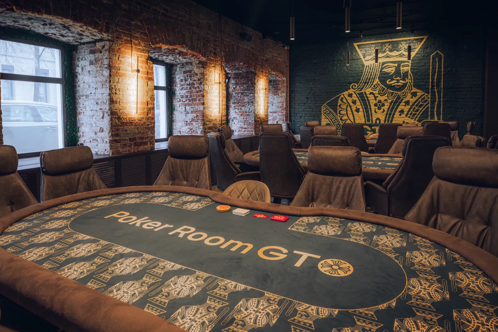 Poker Room GTO club hall with a signature mural and a tournament table
